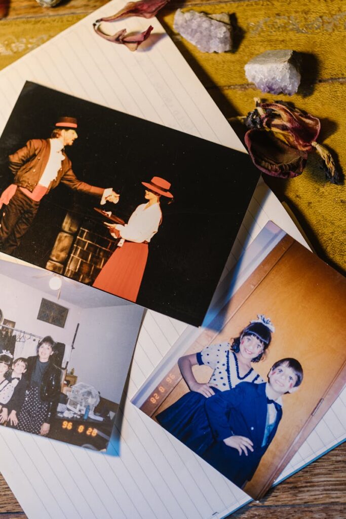 FOTOS DE RECUERDOS Colección de fotografías familiares antiguas con plumas, cristales y flores secas en una libreta.